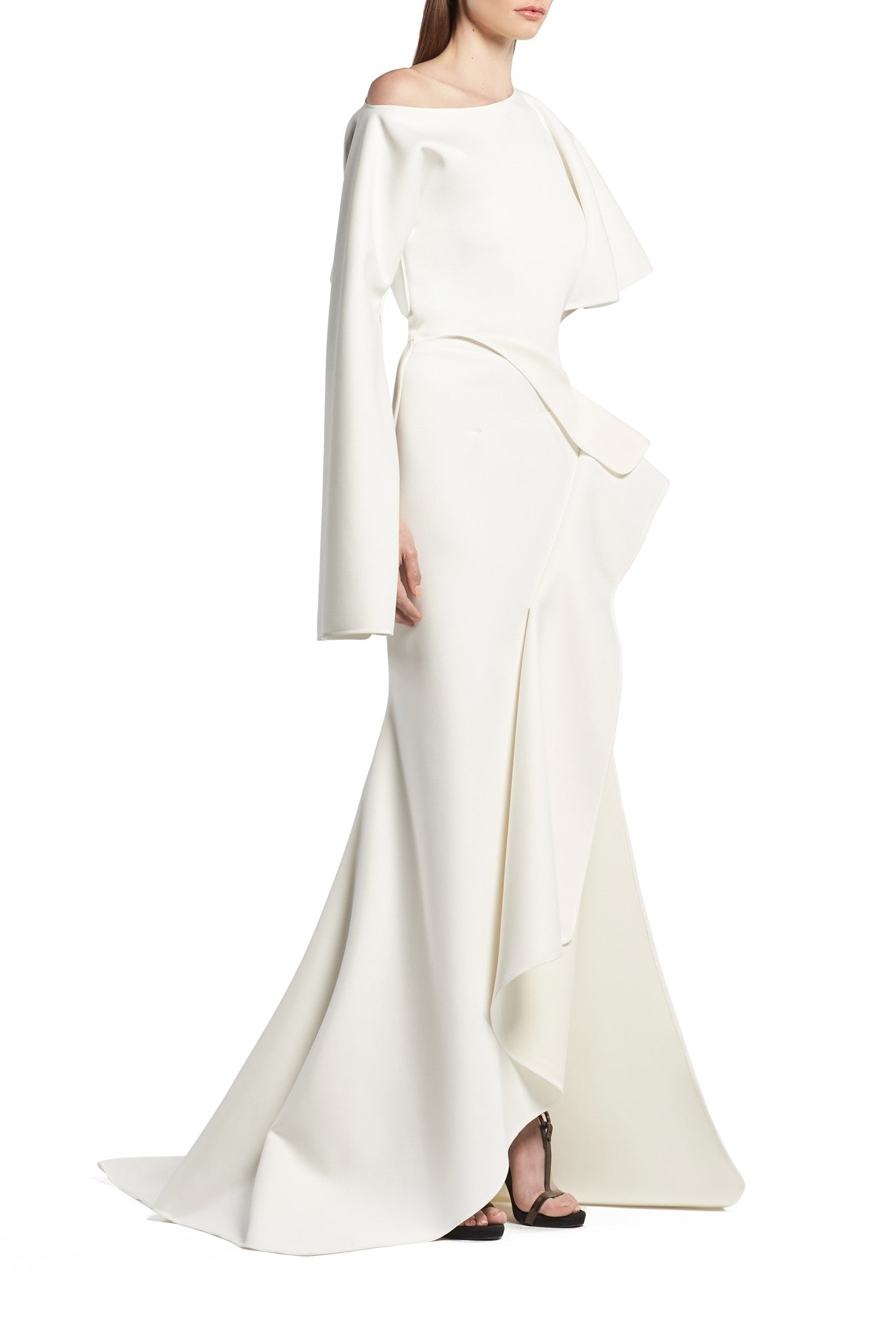 Toni Maticevski Arrival gown. Boat neckline gown with one flutter half sleeve and one long sleeve. Features a ruffle thigh high slit.